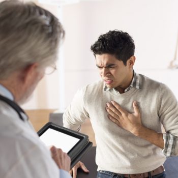 man explaining symptoms to doctor