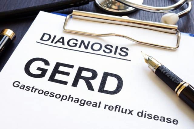 An image of a clipboard form that states Gastroesophageal reflux disease GERD on a clinic desk.