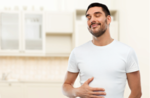 happy full man touching his tummy over kitchen