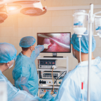 surgeons in operating room with surgery equipment.