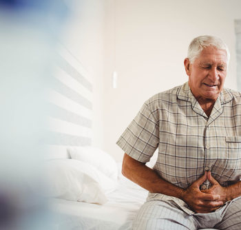 Sick senior man suffering from stomach ache holding his stomach
