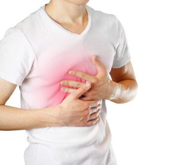 A man holds the Breasts. The pain in his chest. Heartburn