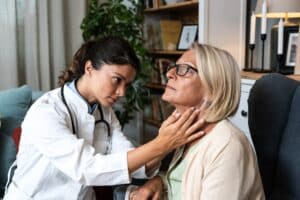Doctor visits elderly woman at home to evaluate symptoms related to Barrett’s Esophagus and provide specialized care